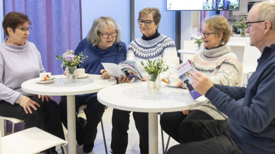 Kuvassa omaishoitajayhdistyksen jäseniä pöydän ääressä.